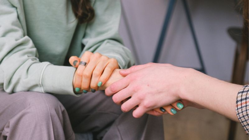 Decorative image of a hand reaching out and clasping another, giving a sense of support to the other person.