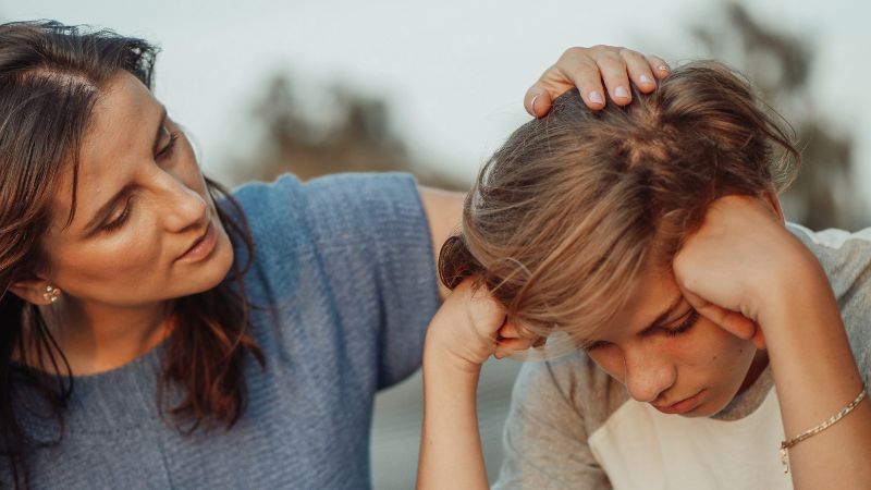 Decorative image of a mother patting her child's head while her child is troubled about something