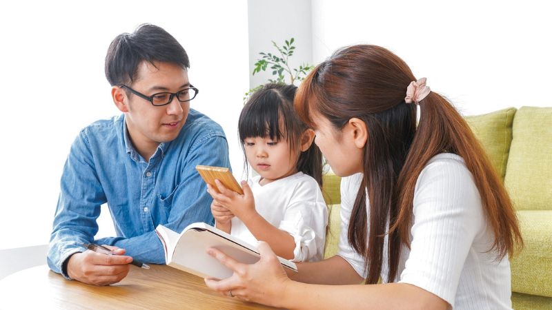 Decorative image of co-parents conversing with their child at the table