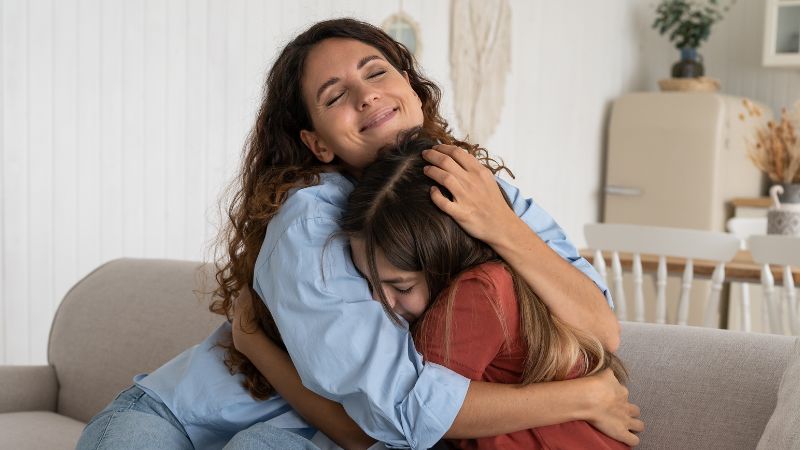 Decorative image of a mother embracing her teenage daughter