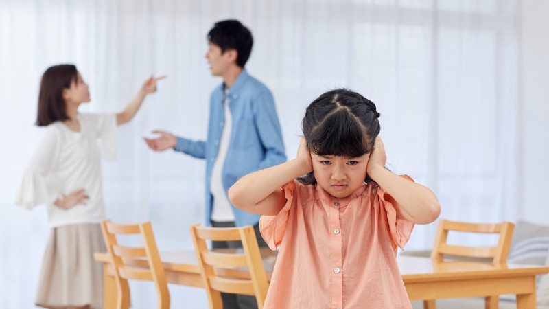 Decorative image of parents arguing while their child presses her hands over her ears to block out the sound
